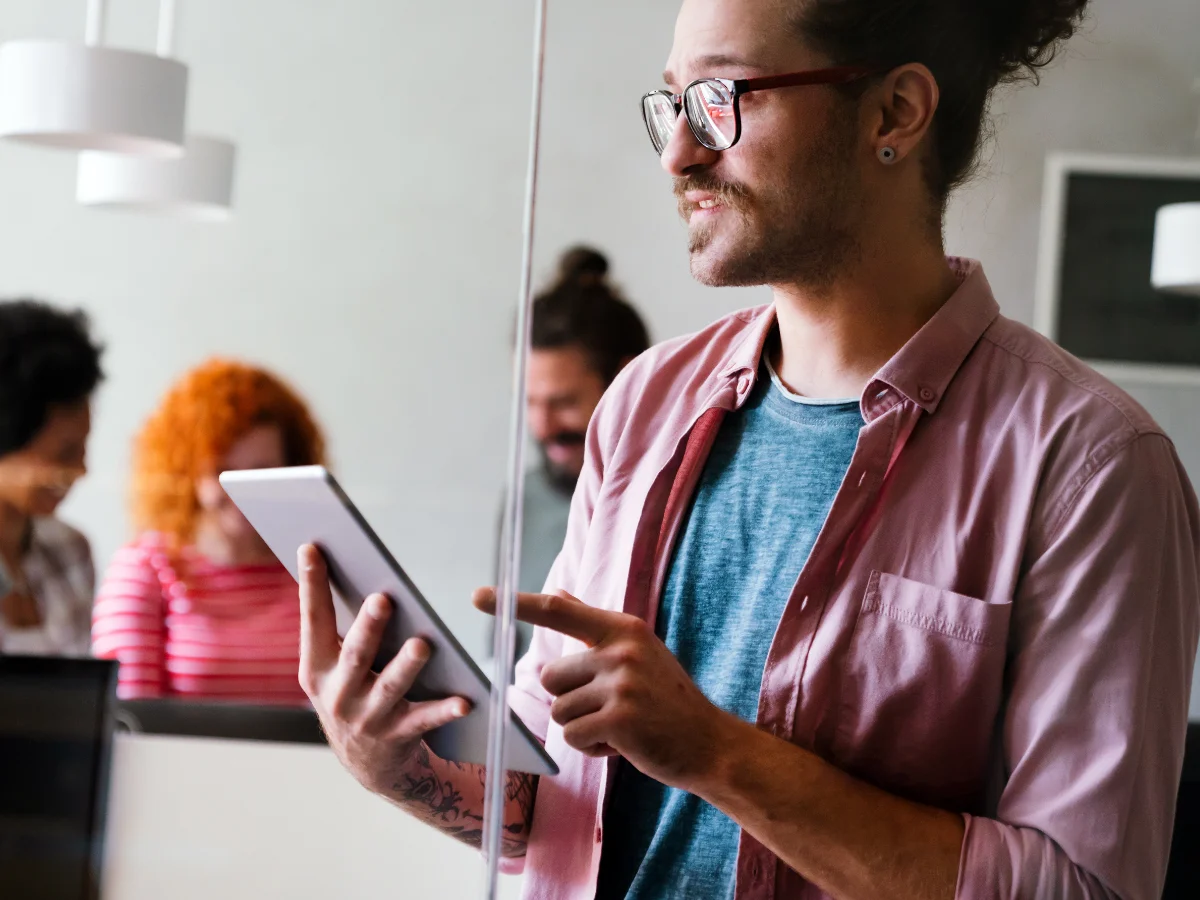 Ein Mann nutzt ein Tablet im Büro, symbolisch für digitales Bewerbermanagement mit canou jobs